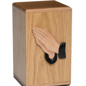 Wooden cremation urn with praying hands