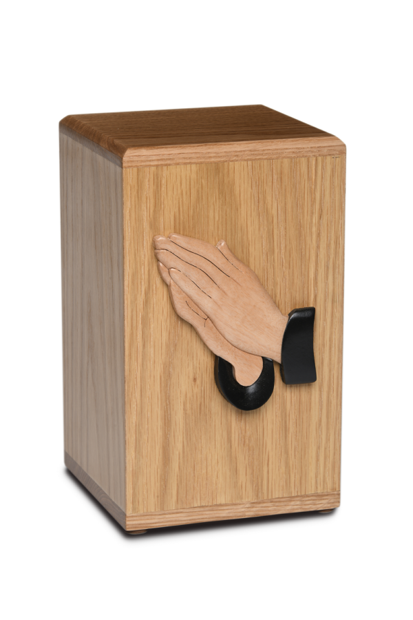 Wooden cremation urn with praying hands